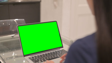 Young Latina Woman Using Laptop with Green Screen