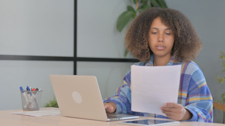 African American Woman and Working on Documents and Laptop