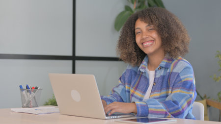 African American Woman Smiling at Camera while Working in Office