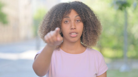 Outdoor Portrait of Young African Woman Pointing at Cameraの写真素材