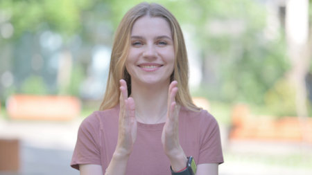 Outdoor Portrait of Young Woman Appreciating By Clappingの写真素材