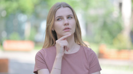 Outdoor Portrait of Pensive Young Woman Thinkingの写真素材