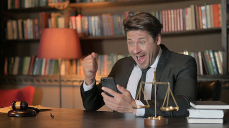 Male Lawyer Celebrating Win on Smartphone in Office