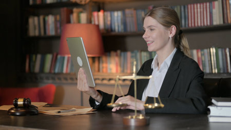 Female Lawyer Doing Video Chat on Tablet in Office