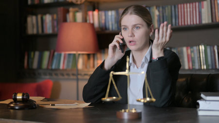 Upset Female Lawyer Arguing on Phone in Officeの写真素材