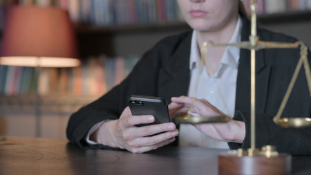 Close Up of Female Judge using Smartphone in Court, Scale of justice