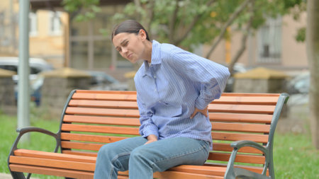 Hispanic Woman Sitting Outdoor with Back Painの写真素材