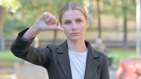 Outdoor Portrait of Businesswoman with Thumbs Downの写真素材