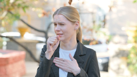 Outdoor Portrait of Sick Businesswoman Coughingの写真素材