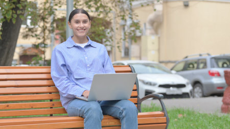 Shocked Woman Looking at Camera while Sitting Outdoorsの写真素材
