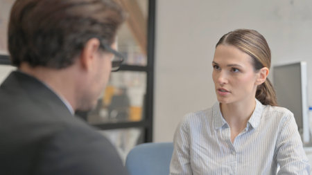 Businesswoman Talking with Businessman in Officeの写真素材