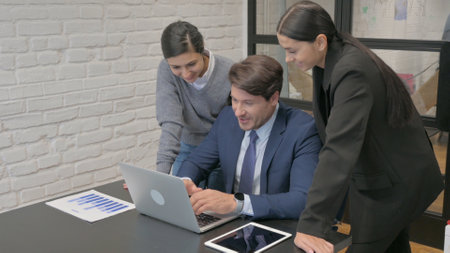 Middle aged Businessman Working with Teammate on Laptopの写真素材