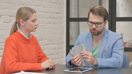 Businessman Paying Money to Young Colleague
