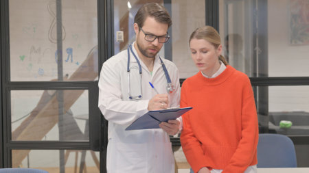 Doctor Discussing Medical Report with Patient in Clinic