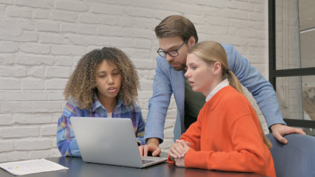 Multiethnic Entrepreneurs Using Laptop in Officeの写真素材