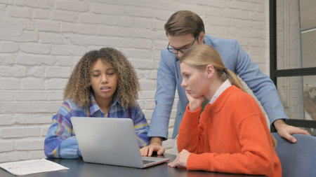 Multiethnic colleagues working together on a laptop.の写真素材