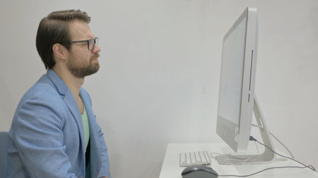 Middle Aged Man Shocked by Loss on Desktop Computer in Office