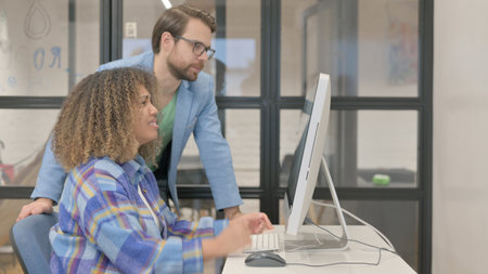 Young Teammates Working on Desktop