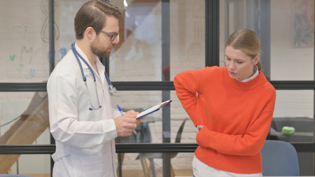 Woman with Back Pain Consulting Orthopedic Doctor