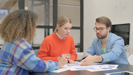 Mixed Race Entrepreneurs Doing Paperwork in Office Together
