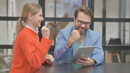 Business People Celebrating Success on Tablet