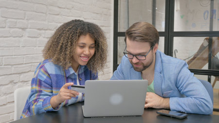 Teammates Excited for Online Shopping via Laptop