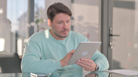 Middle Aged Man Using Digital Tablet