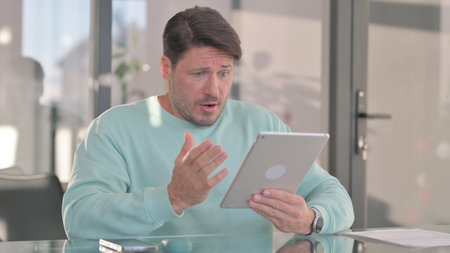 Middle Aged Man with Loss on Tablet