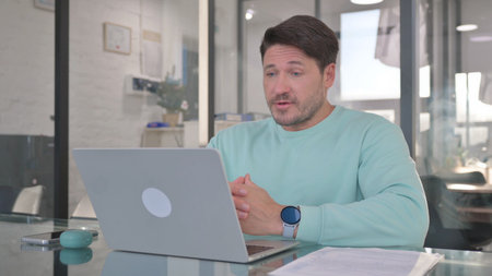 Casual Man Chatting Online on Laptop while Sitting