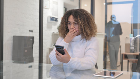 African Woman Shocked by Loss on Phone in Office
