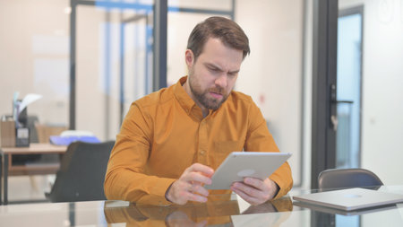 Middle Aged Businessman with Loss on Tabletの写真素材