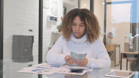 African Woman Doing Financial Calculations, Counting Moneyの写真素材