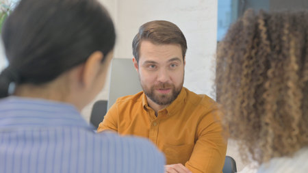 Close up of Businessman Talking with Female Teammatesの写真素材