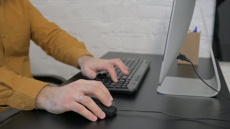 Side View of Hands Typing on Keyboard of Computer