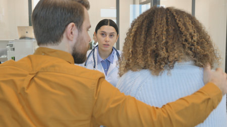Hispanic Doctor Sharing Bad Results with Coupleの写真素材