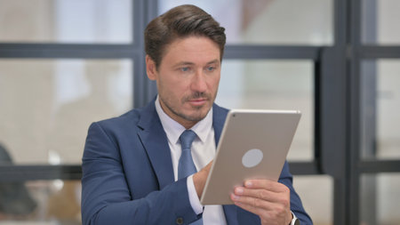 Portrait of Middle Aged Businessman Using Digital Tabletの写真素材