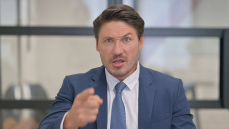 Portrait of Angry Middle Aged Businessman Talking in Angerの写真素材