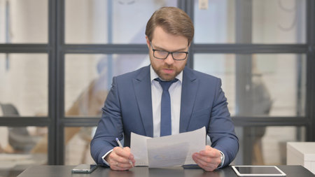 Young Businessman Feeling Upset while Reading Contract