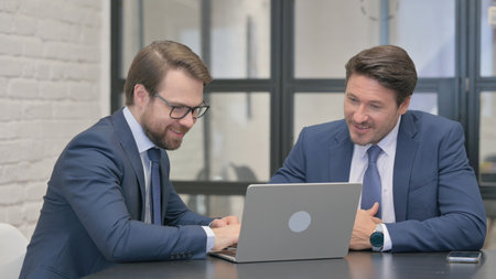 Business People Celebrating Online Success on Laptopの写真素材