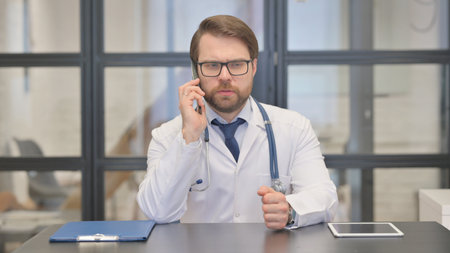 Doctor Talking on Phone with Patient in Hospitalの写真素材