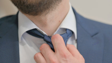 Close up of Tired Businessman opening Tie Knotの写真素材