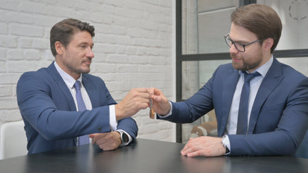 Businessman Giving Home Keys to Customer after Saleの写真素材