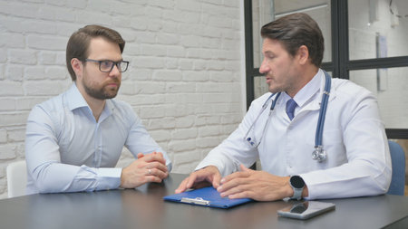 Mature Adult Doctor Discussing Health Plan with Patientの写真素材