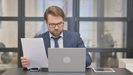 Young Businessman Doing Paperwork at Workの写真素材