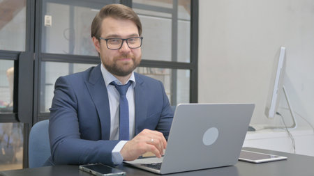 Businessman Shaking Head in Acceptance at Workの写真素材