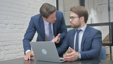 Standing Businessman in Argument with Colleague at Workの写真素材