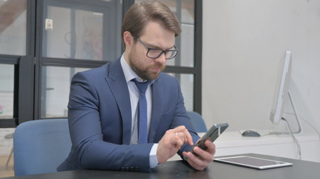 Young Businessman Browsing Smartphone, Typing Messageの写真素材