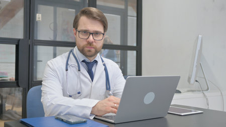 Serious Mature Adult Doctor Looking at Camera in Hospitalの写真素材