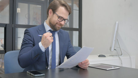 Young Businessman Celebrating New Contract Resultsの写真素材
