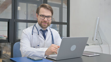 Smiling Mature Adult Doctor Looking at Camera in Hospitalの写真素材